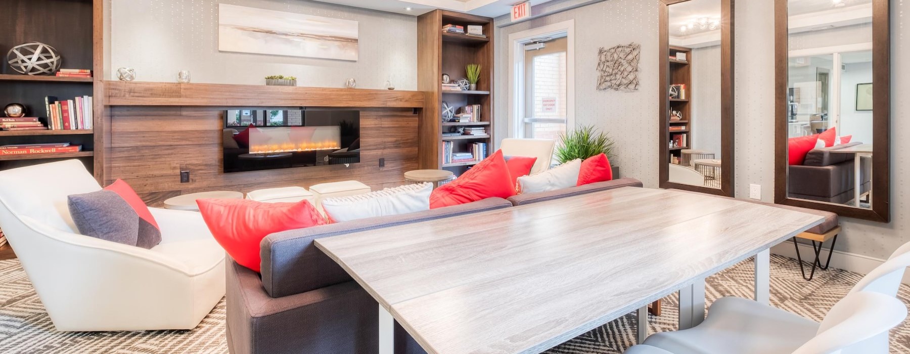 a clubroom with a table, chairs and a fireplace