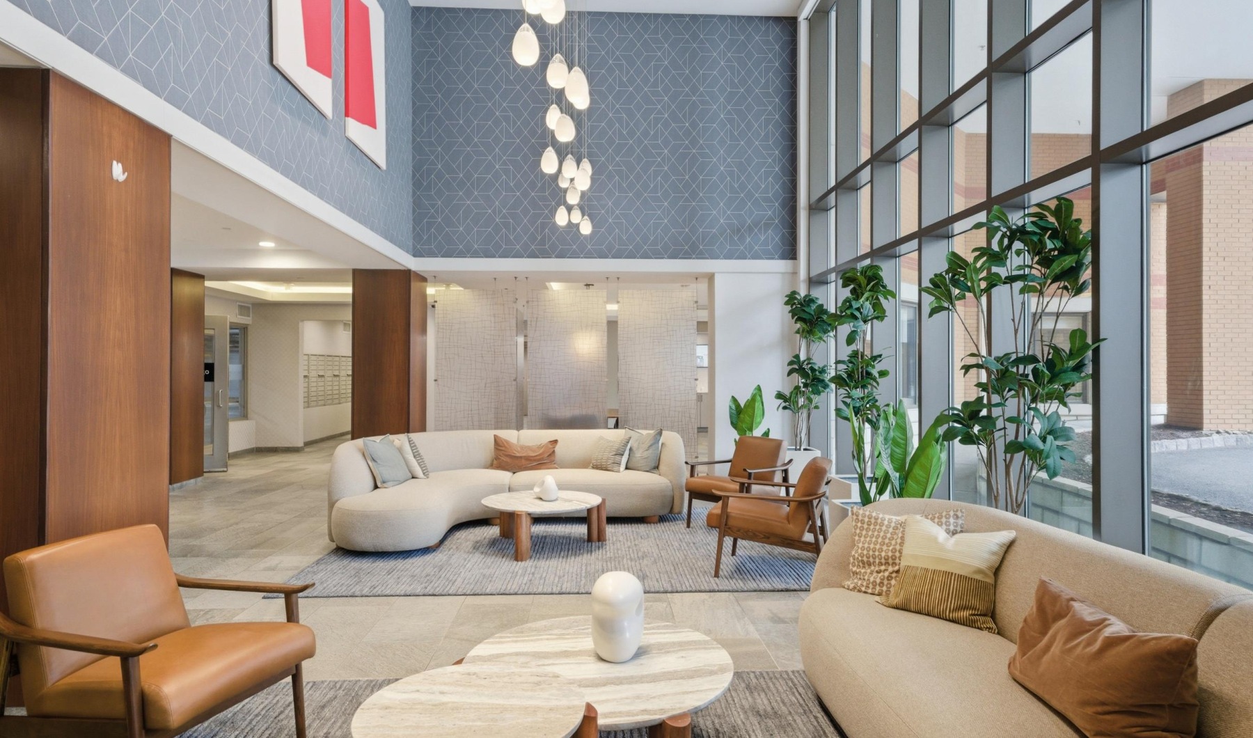  A modern lobby lounge with a large window and a variety of seating options.