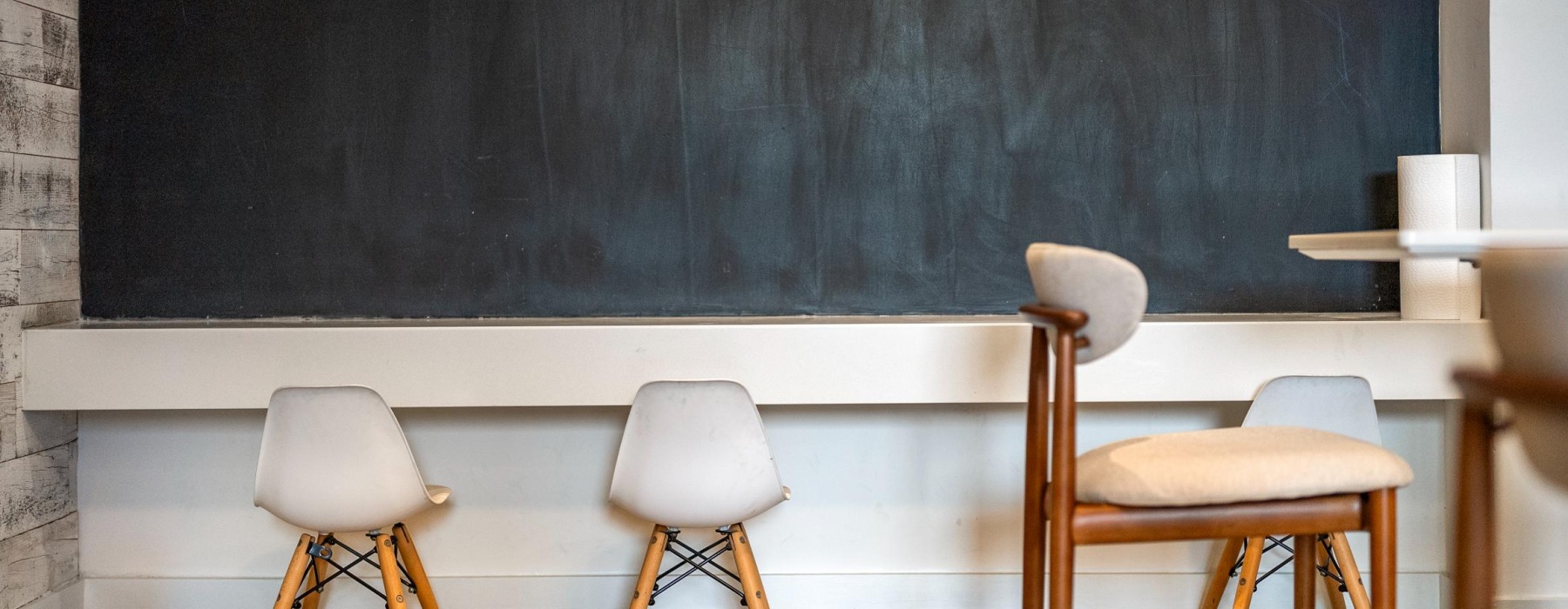 a resident clubroom with chalk board, small chairs, and other seating