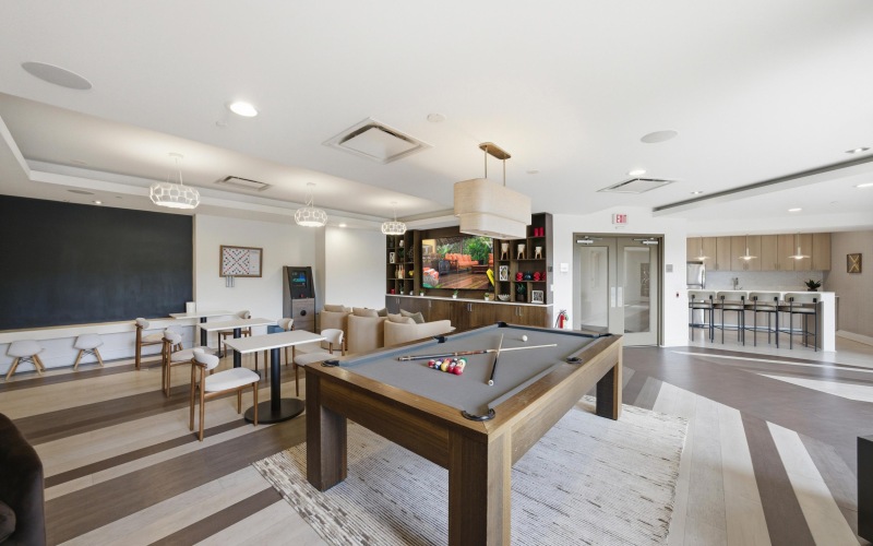 a clubroom with a pool table and chairs