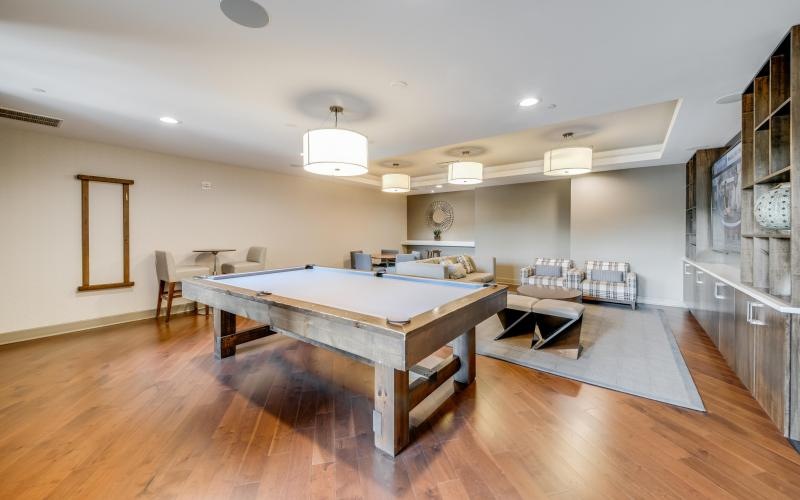 a clubroom with a pool table and chairs